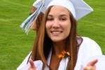 Girl giving thumbs up at high school graduation.